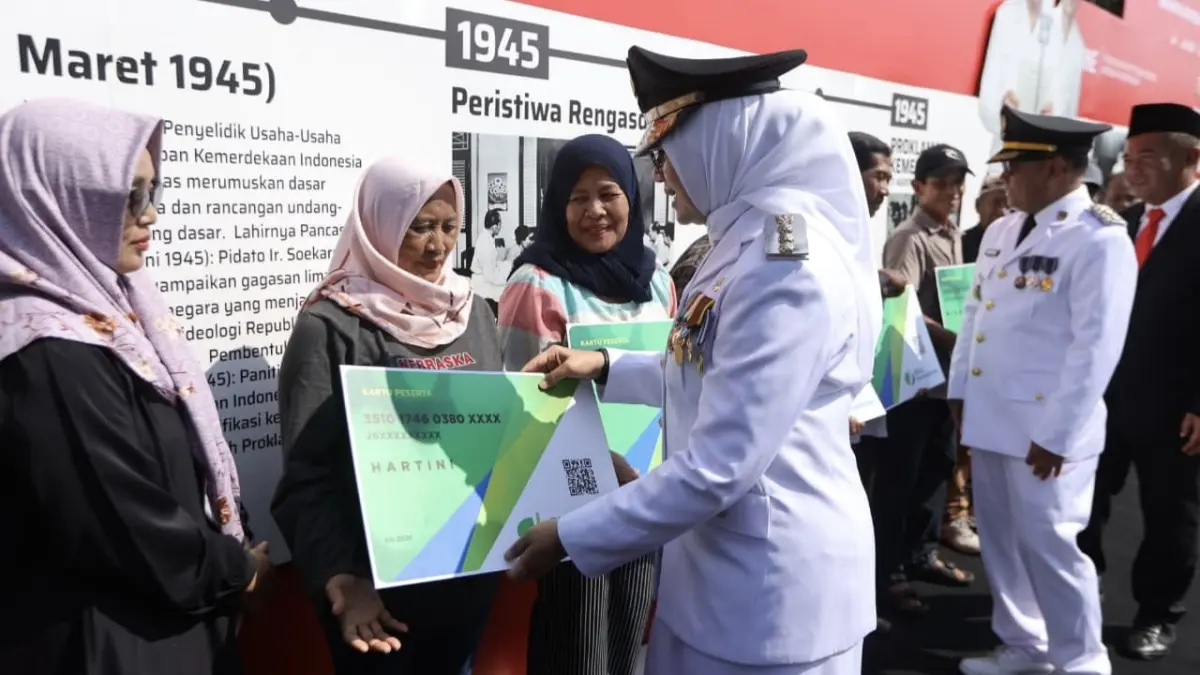 Bupati Banyuwangi menyerahkan simbolis kepesertaan BPJS Ketenagakerjaan kepada perwakilan pekerja informal dalam Upacara Peringatan 17 Agustus di Taman Blambangan, Senin (17/8). (Portal Banyuwangi)