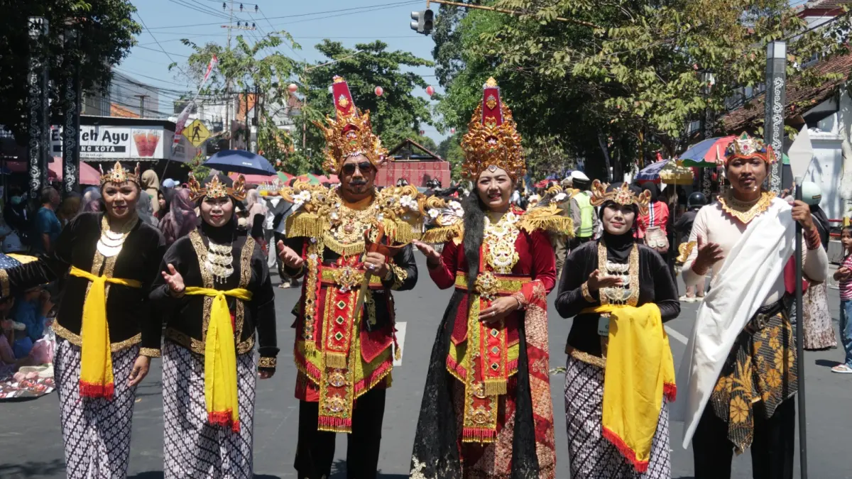 IKON : Kepala Smagi Taruna Bangsa I Ketut Renen (tengah) bersama istri mengenakan kostum Raja Blambangan dengan diapit para Wakasek di Karnaval Kebangsaan pada Kamis (13/8). (SmagiTV untuk RadarBanyuwangi.id)