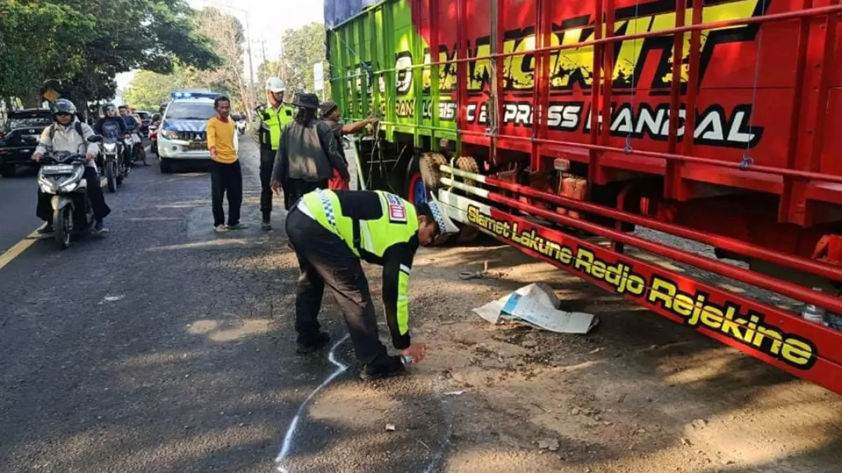 Petugas Satlantas Polresta Banyuwangi melakukan olah TKP kecelakaan yang meliabtkan sepeda mooootor dengan truk di dekat Pelabuhan Tanjungwangi, Selasa (18/8). (Satlantas Polresta Banyuwangi)