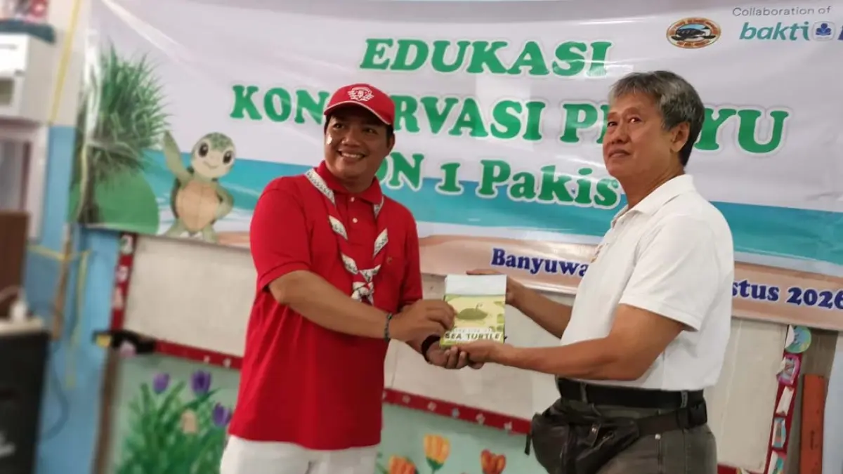 Pendiri BSTF Wiyanto Hadinatojo (kiri) menyerahkan secara simbolis buku edukasi konservasi Penyu kepada Kepala SDN 1 Pakis Andi Eko Pramono. (Gerda/Radar Banyuwangi)