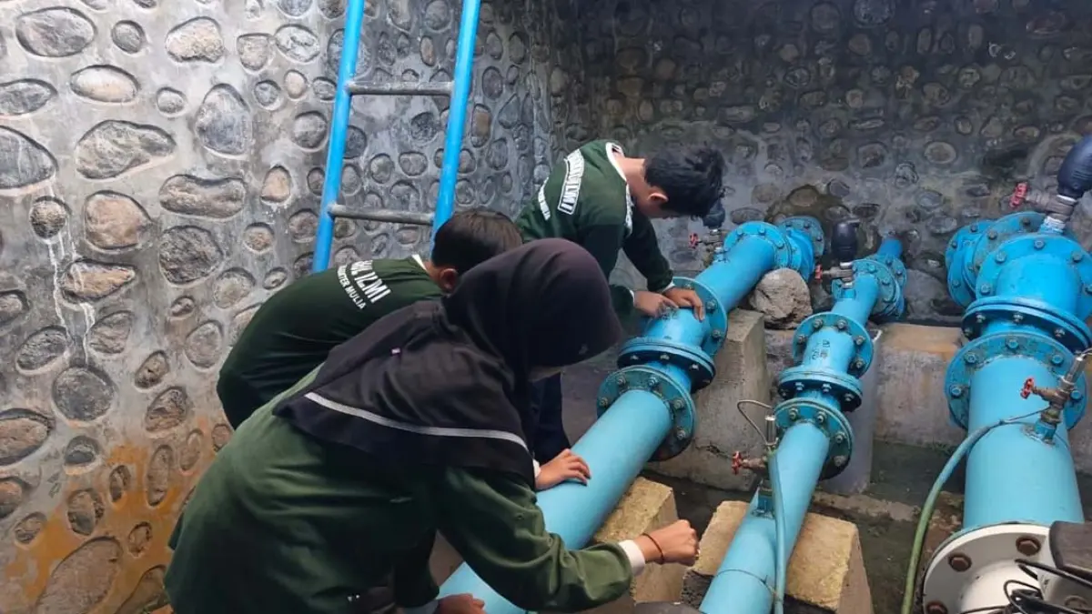Sejumlah siswa asal SD Gugus 2 Glagah melihat langsung pipa berukuran jumbo di kompleks tempat penampungan air di Kelurahan/Kecamatan Kalipuro. Pipa ini menjadi bagian jaringan distribusi air ke rumah-rumah warga. (Ksatria Raya/Radar Banyuwangi)