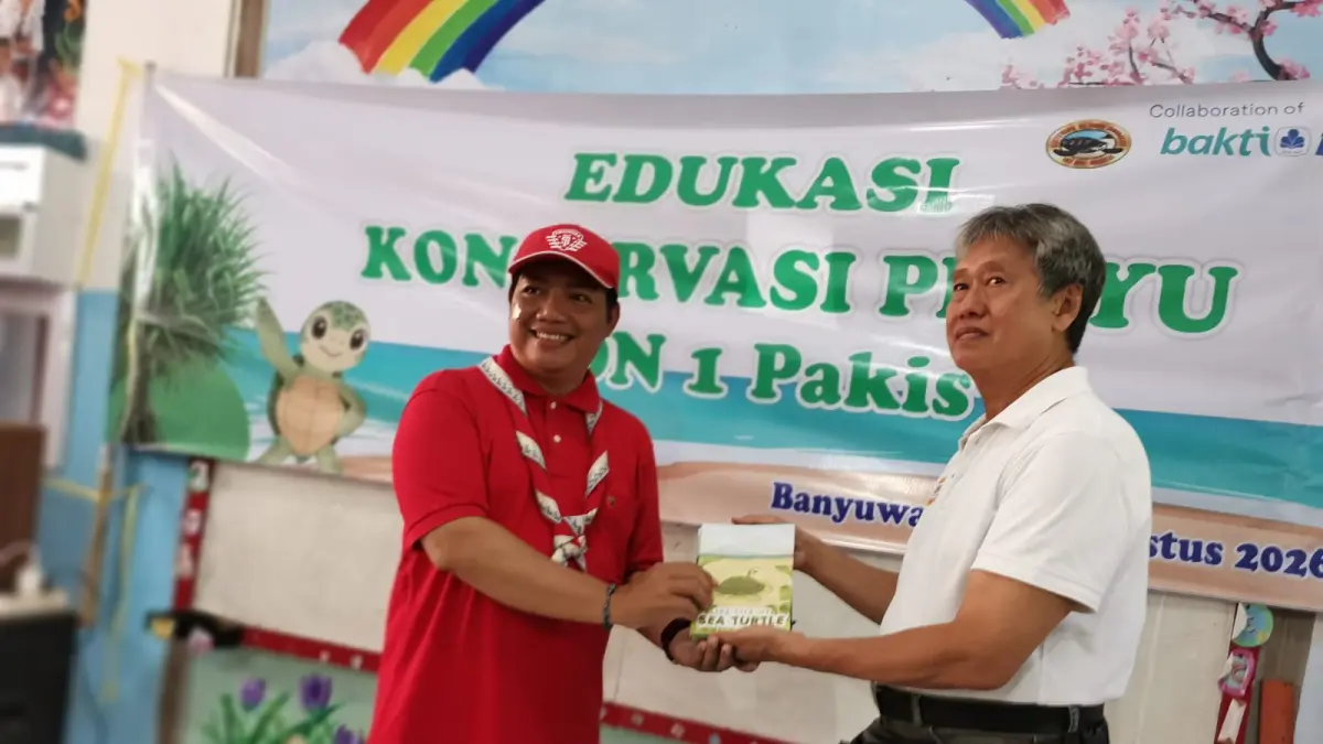 KOLEKSI PERPUSTAKAAN : Pendiri BSTF Wiyanto Hadinatojo (kiri) menyerahkan beberapa buku hasil karya relawan kepada Kepala SDN 1 Pakis Andi Eko Pramono. Materi buku tersebut berbentuk dongen edukasi tentang pelestarian Penyu yang dikemas dengan cerita bergambar. (Gerda/RadarBanyuwangi.id)