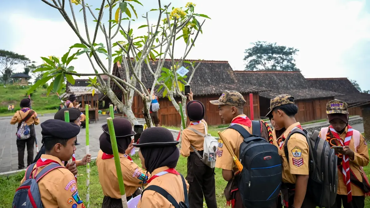 Anggota Pramuka memindai barcode untuk menuntaskan misi pada event Radar Banyuwangi Digital Mission Race 2026 di Agro Wisata Tamansuruh pada Sabtu (22/8). (Ramada Kusuma/Radar Banyuwangi)