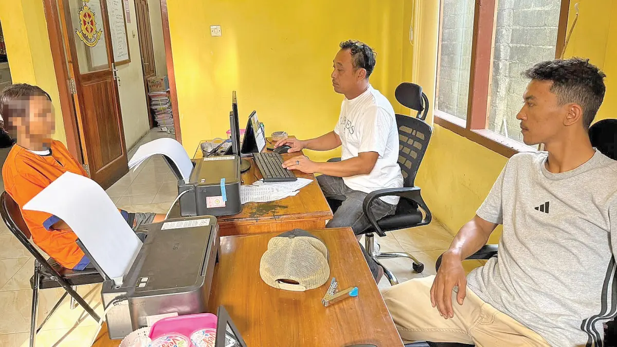 Kaniterkrim Polsek Pesanggaran, Aiptu Heru Prasetyo melakukan pemeriksaan  terhadap S, terduga pelaku penipuan bos home stay di Mapolsek Setempat. (Heru untuk Radar Banyuwangi)