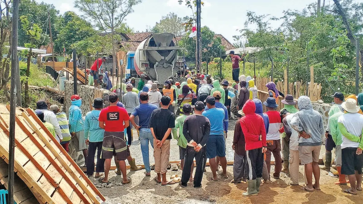 Warga Sidowangi dan Dusun Badolan, Desa Bajulmati, bergotong royong mengerjakan pengecoran lantai jembatan penghubung kedua wilayah. (Muansin untuk Radar Banyuwangi)