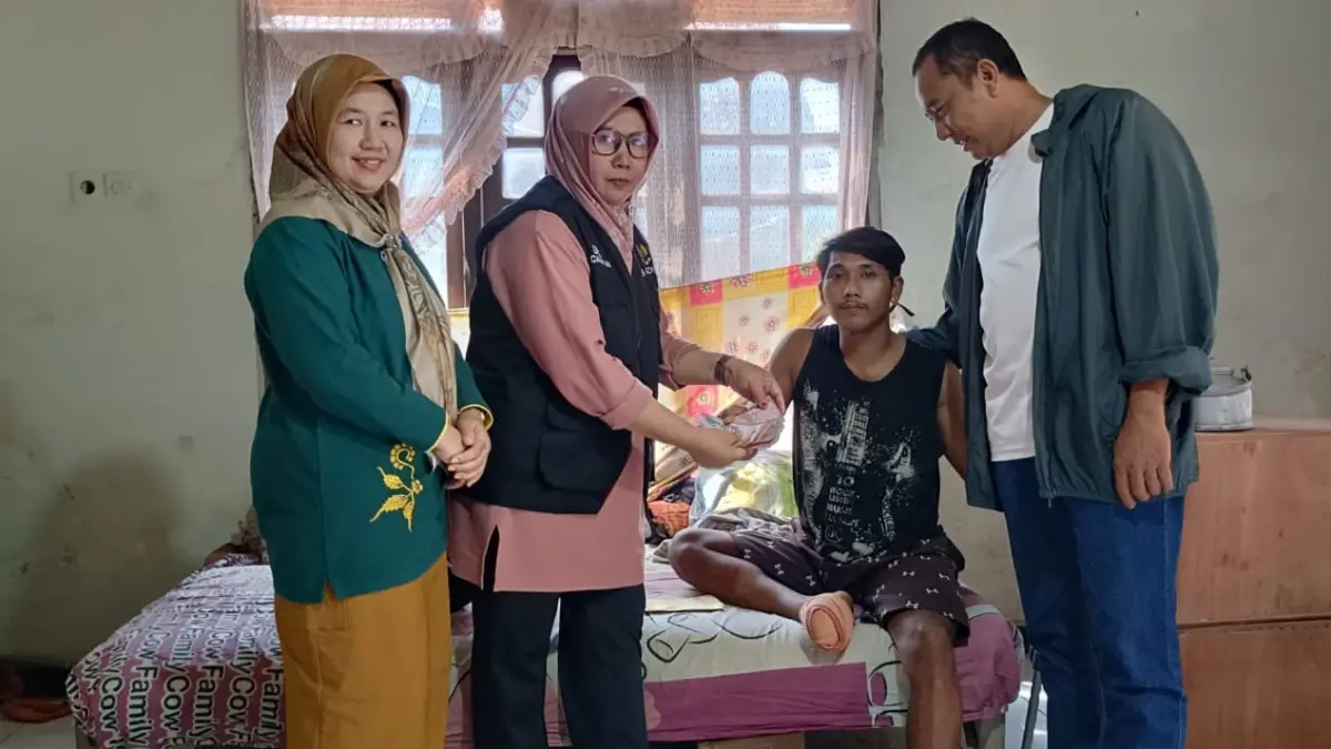 Ketua UPZ Kecamatan Tegaldlimo Fazza Rouzi menyerahkan bantuan biaya pengobatan kepada Bektiyo disaksikan Kades Kedungasri. (Baznas untuk Radar Banyuwangi)