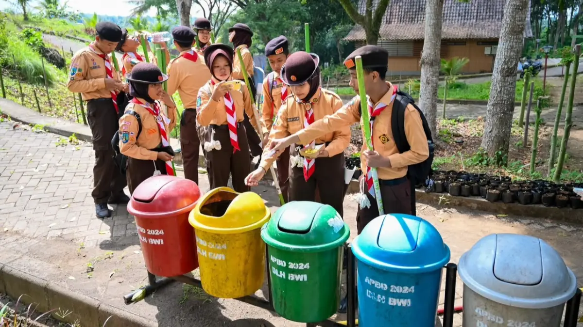 Peserta Radar Banyuwangi Digital Mission Race (Digi MR) 2026 memilah sampah organik dan anorganik dalam salah satu misi di Agro Wisata Tamansuruh, Sabtu (22/8). (Ramada Kusuma/Radar Banyuwangi)