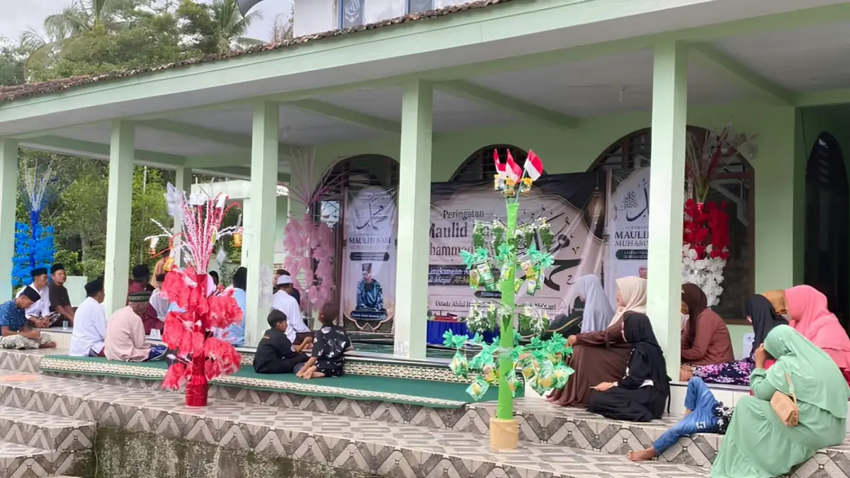 Warga menata kembang endhog pada jodhang bernuansa merah putih dalam tradisi ndog-ndogan untuk memperingati Maulid Nabi Muhammad SAW. Hiasan tersebut menjadi bentuk kreativitas masyarakat yang memadukan tradisi keagamaan dengan semangat bulan kemerdekaan. (Rizkia untuk Radar Banyuwangi)