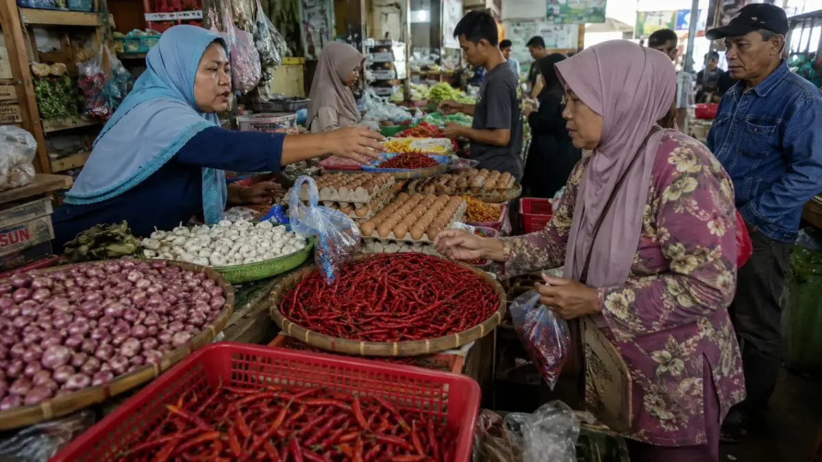 Aktivitas pedagang melayani pembeli di pasar tradisional Banyuwangi, Kamis (27/8). Harga sejumlah komoditas, termasuk cabai rawit merah, telur ayam ras, bawang, dan ikan segar, tercatat mengalami kenaikan. (ChatGPT)