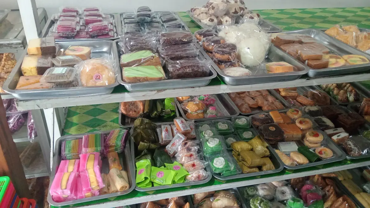Beragam jajanan tradisional tertata di meja pedagang pasar, menawarkan pilihan makanan sederhana dengan cita rasa khas dan harga yang terjangkau. (Balquisse untuk Radar Banyuwangi)