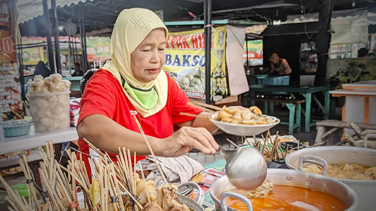KUDAPAN MALAM: Penjual lontong kikil di barat Pasar Kota Bojonegoro. Ada kikil yang ditusuk menyerupai sate dan kuah kare pedas. (DANI WAHYU ALFIANSYAH/RADAR BOJONEGORO)