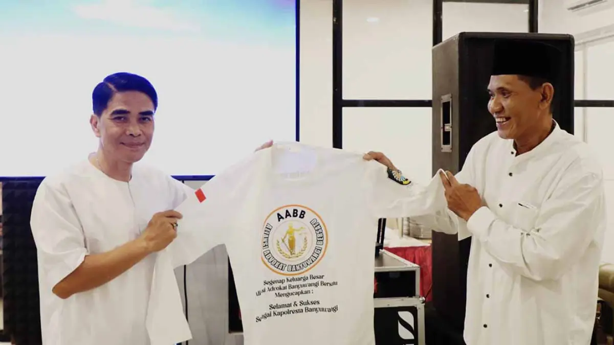 Ketua AABB R Bomba Sugiarto (kanan) memberikan kaus kepada Kapolresta Banyuwangi, Kombespol Rofiq Ripto Himawan (kiri) sebagai bentuk apresiasi, Jumat (29/8). (Bomba Sugiarto for Radar Banyuwangi)