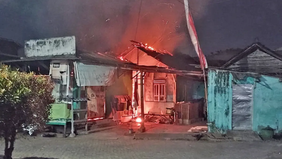 MENYALA: Rumah yang terhubung dengan toko di Desa Jajag, Kecamatan Gambiran, terbakar dini hari, Jumat (28/8). (Irfan Muklisin for Radar Banyuwangi)