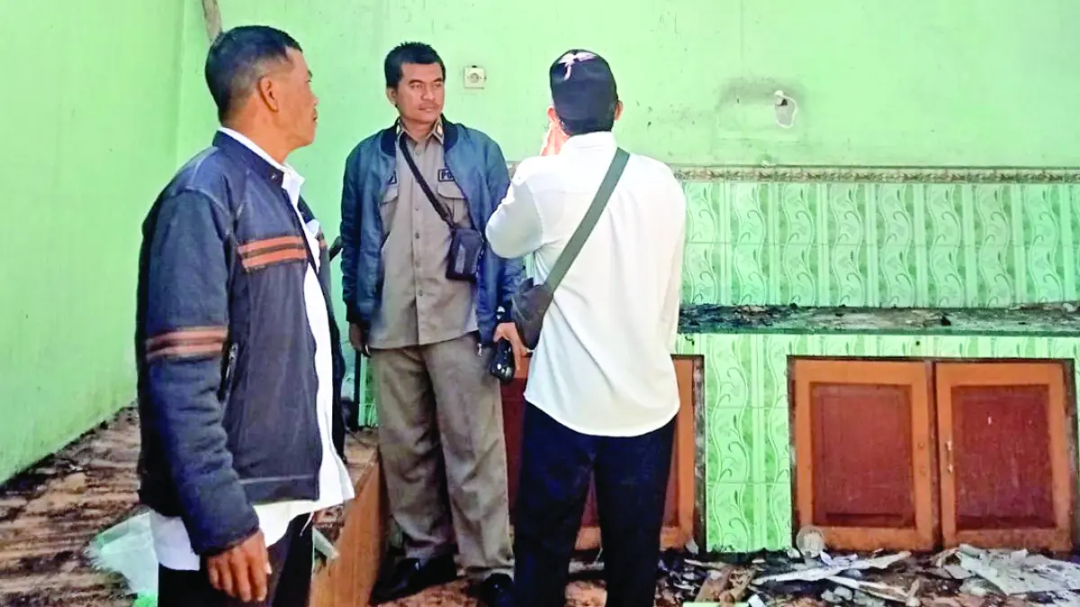 RUSAK: Petugas Kecamatan Kalibaru mengecek kondisi rumah Suyono yang terbakar, Jumat (28/8). (MAD for Radar Banyuwangi)
