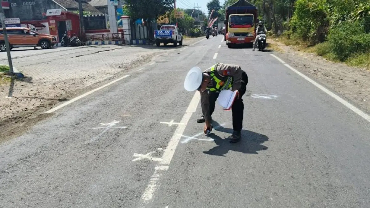 TANDAI LOKASI: Anggota Satlantas Polresta Banyuwangi melakukan olah TKP di Jalan Raya Desa Sumbersari, Kecamatan Srono, Jumat (28/8). (Pepri for Radar Banyuwangi)