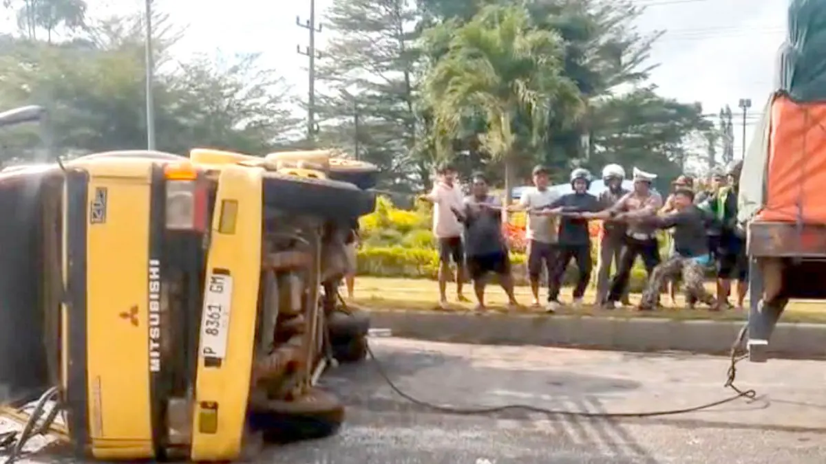 EVAKUASI CEPAT: Warga bersama petugas Satlantas Polresta Banyuwangi bahu-membahu mengevakuasi truk tangki bermuatan air yang terguling di depan RTH Kedayunan, Kecamatan Kabat, Selasa (1/9). (Pepri for Radar Banyuwangi)