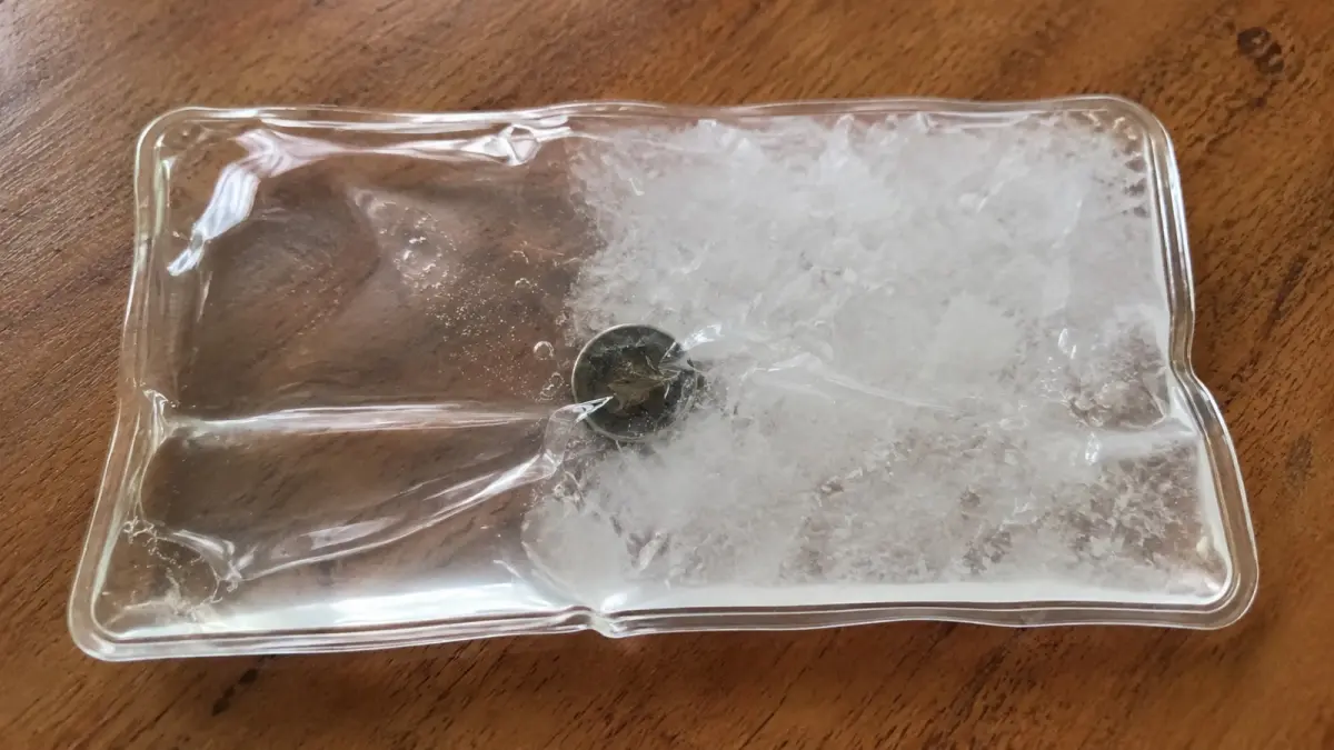 Larutan sodium acetate dalam reusable heat pack mulai berubah menjadi kristal setelah proses aktivasi. Kristalisasi tersebut melepaskan energi dalam bentuk panas tanpa memerlukan api atau listrik saat digunakan. (ChatGPT)
