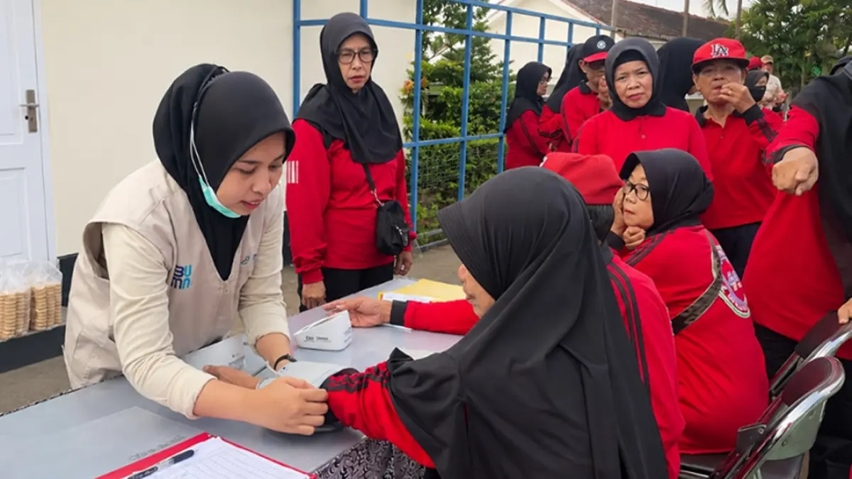 PENDAMPINGAN: Petugas kesehatan IHC RSU Bhakti Husada sedang melakukan pemeriksaan kesehatan pada peserta kegiatan senam lansia. (RUSTIDA for Radar Banyuwangi)