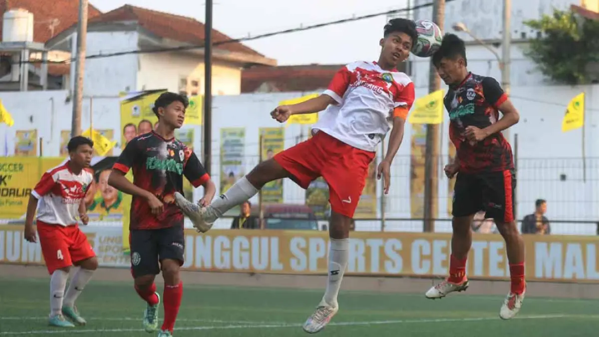 Penggawa Tim SMAN 1 Tumpang berebut bola atas dengan pemain MAN 1 Malang dalam laga semifinal pertama Bahlil Mini Soccer Asyik Menuju Puncak Zona Malang, Selasa sore (1/9). (Darmono/Radar Malang)