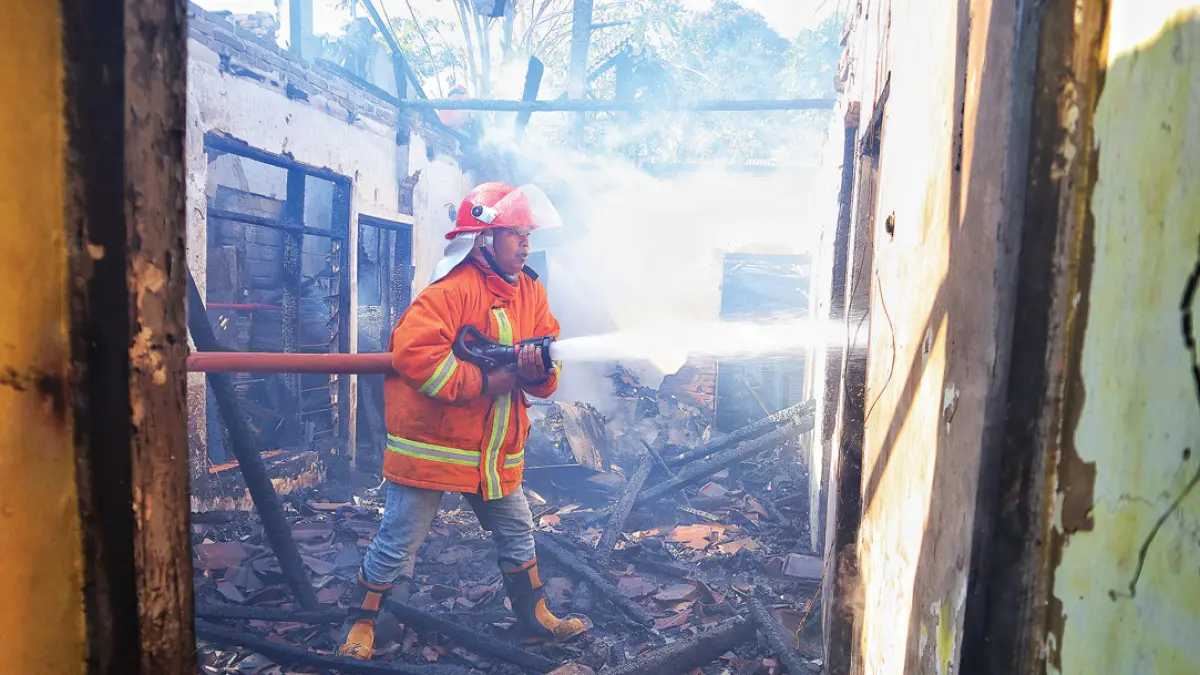 Petugas Damkarmat Sektor Genteng saat memadamkan api di rumah warga Dusun Krajan I, Desa Kembiritan, Kecamatan Genteng, Selasa (1/9). (Salis Ali/Radar Banyuwangi)