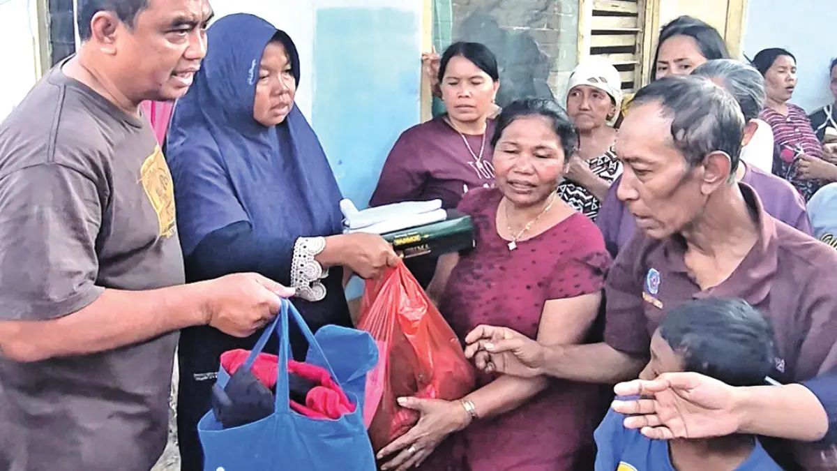 KOMPAK: Warga Dusun Krajan I, Desa Kembiritan, Kecamatan Genteng, menyerahkan bantuan pakaian layak pakai kepada Mujaini pada Selasa (1/9). (Salis Ali/Radar Banyuwangi)