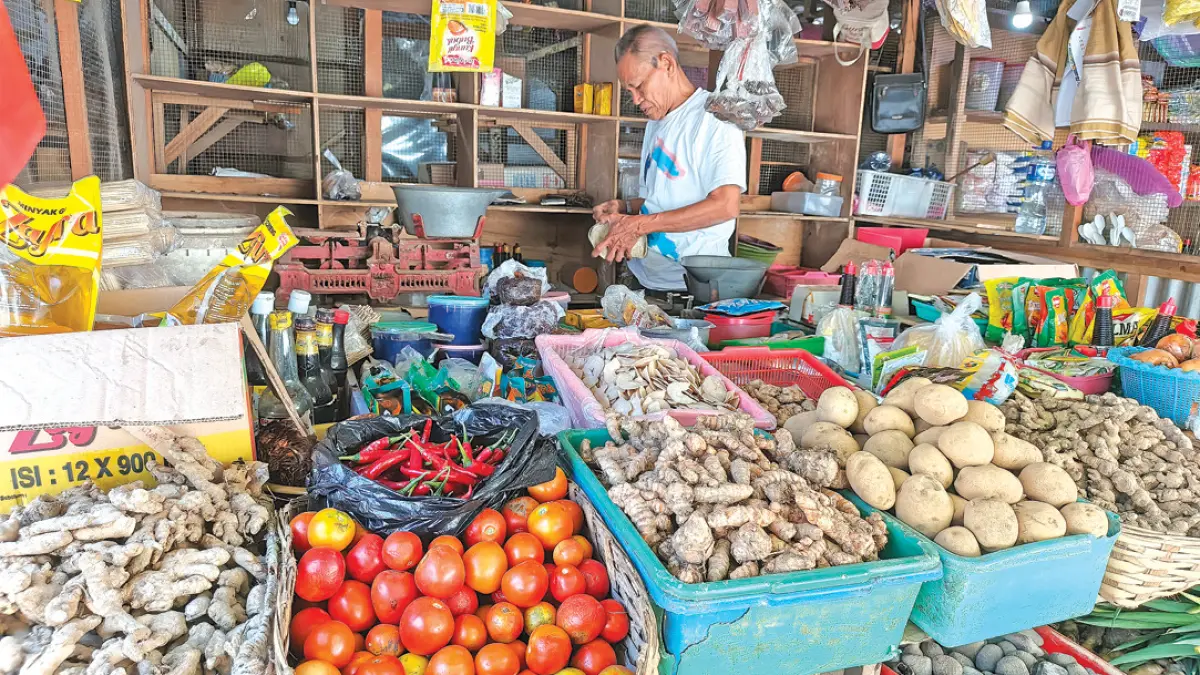 Salah satu pedagang sembako di pasar Banyuwangi sedang melayani pembeli, Rabu (2/8). (Ksatria Raya/Radar Banyuwangi)
