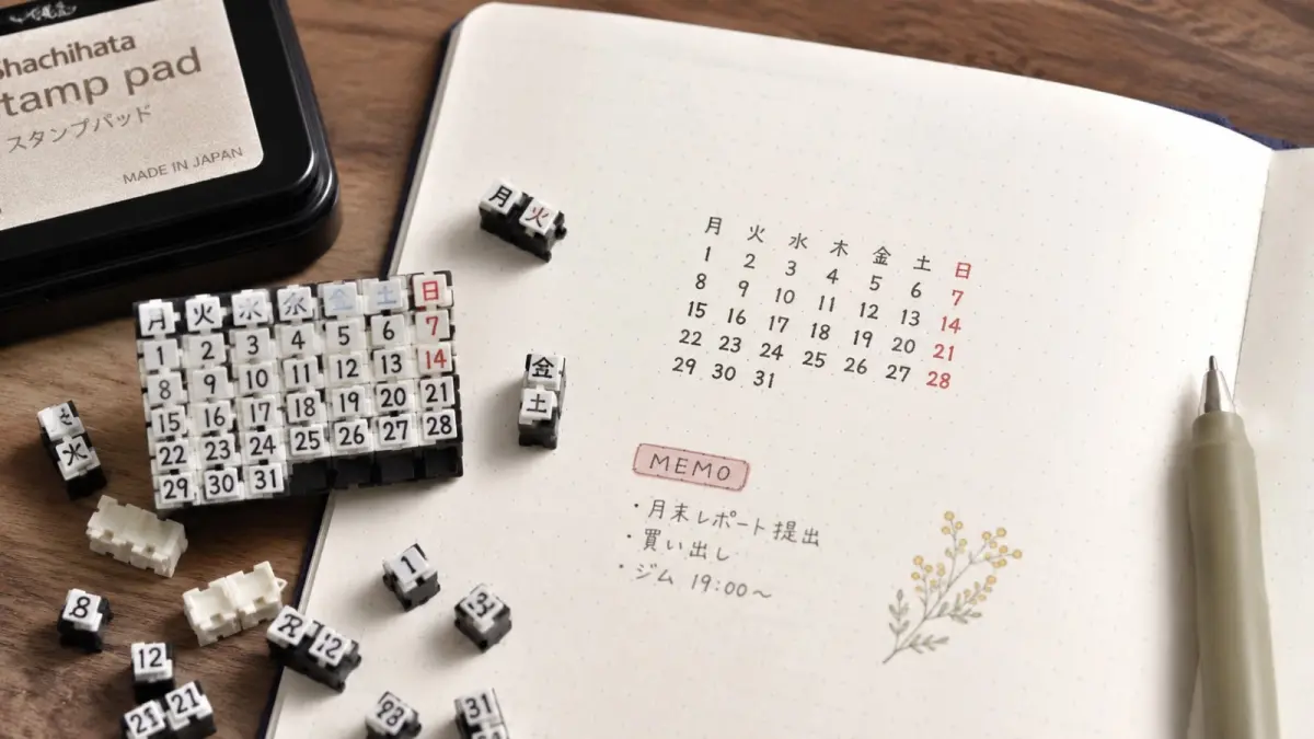 SHACHIHATA Connecting Calendar Stamp menggunakan kepingan stempel yang dapat dirangkai untuk membuat susunan kalender pada jurnal, notebook, atau planner. (ChatGPT)