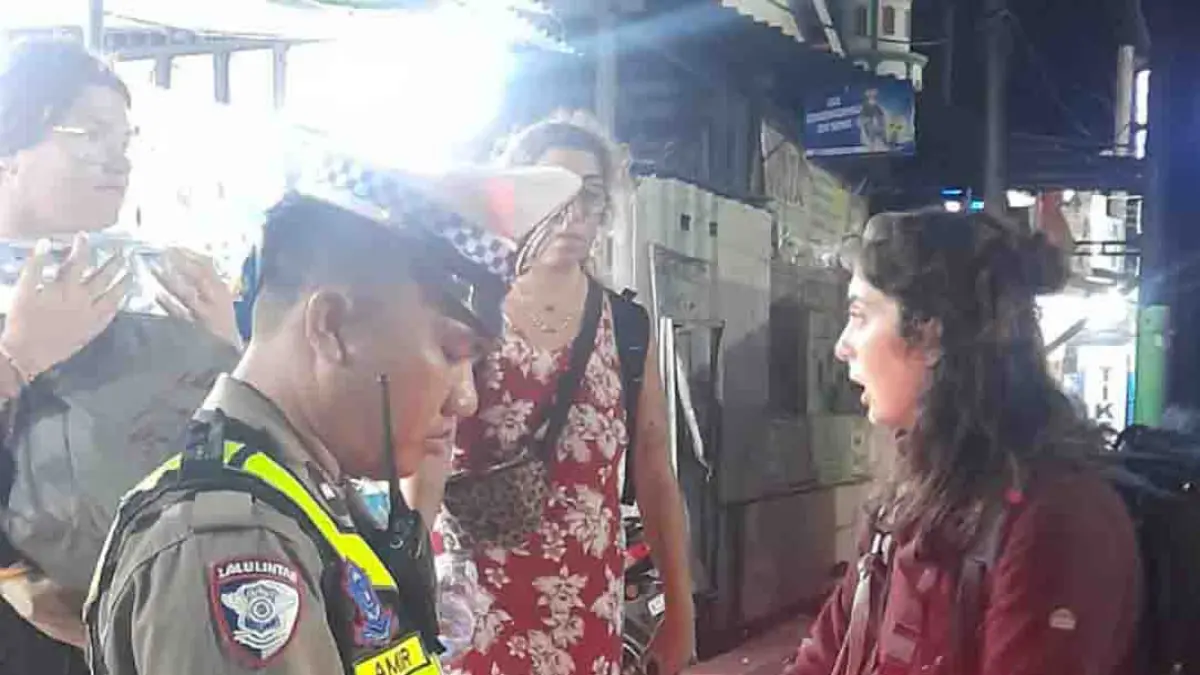BANTU WISATAWAN: Anggota Satlantas Polresta Banyuwangi membantu wisatawan mencarikan angkutan umum untuk menghindari kemacetan di Pelabuhan ASDP Ketapang Banyuwangi, Kamis (3/9). (Humas Polresta Banyuwangi)