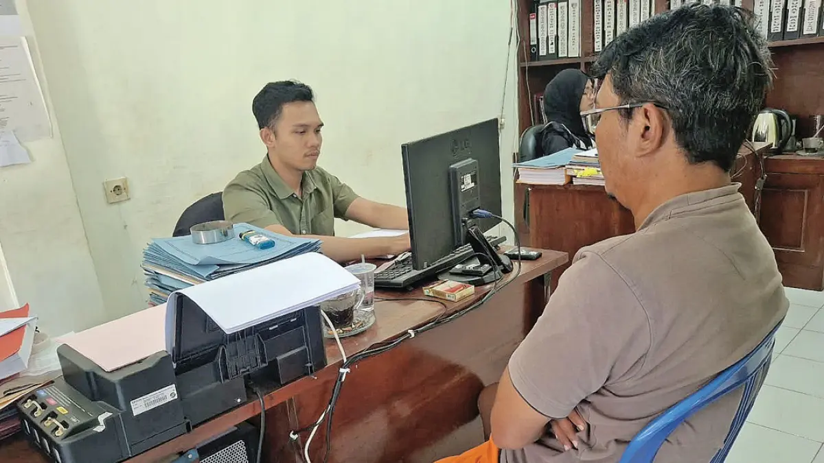 Penyidik Unit Reskrim Polsek Kalibaru memeriksa DP, seorang pekerja proyek di kawasan PT Jagonya Ayam Indonesia (JAI) Desa Kebonrejo, Kecamatan Kalibaru, Kamis (3/9). (Salis Ali/Radar Banyuwangi)
