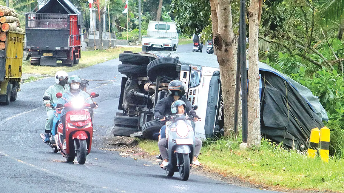 LAKA TUNGGAL: Truk Isuzu bernomor polisi N 9709 EK terguling di Jalan Raya Jember–Banyuwangi, tepatnya di Dusun Wadungdolah, Desa Kaligondo, Kecamatan Genteng, Senin (7/9). (Salis Ali/Radar Banyuwangi)