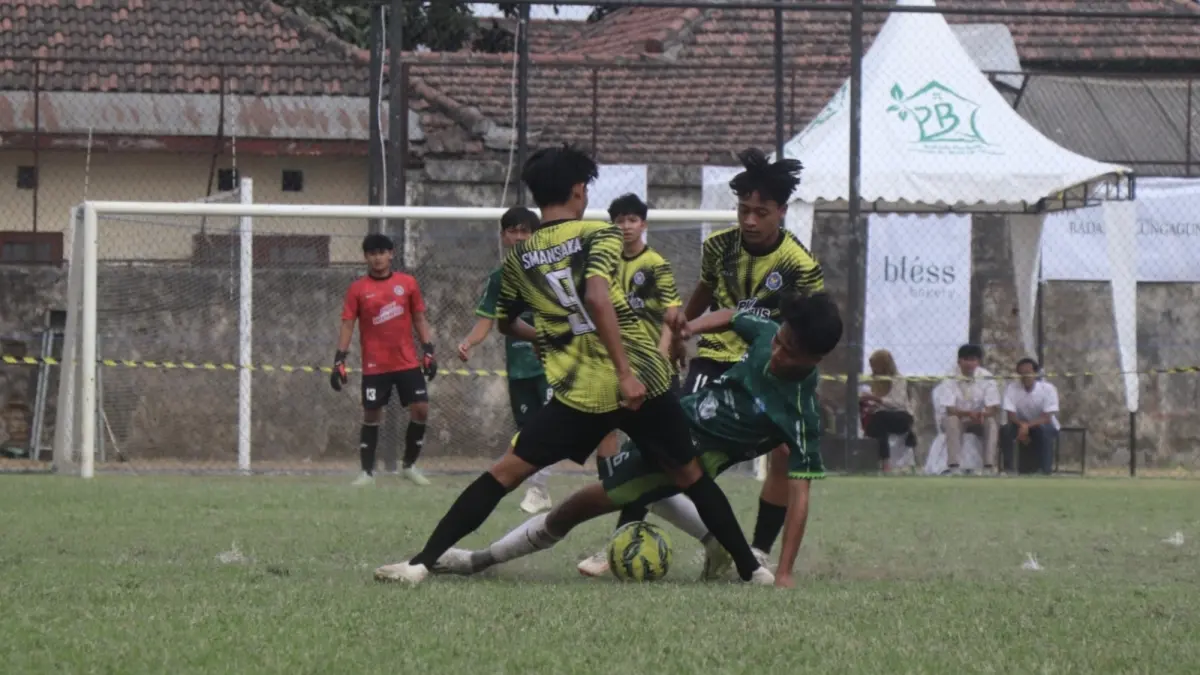 Dua pemain SMAN 1 Kauman mengepung gelandang SMAN 1 Trenggalek dalam perebutan tiket final Bahlil Mini Soccer Asyik Menuju Puncak Zona 3 Tulungagung. (DR Perdana/Radar Tulungagung)