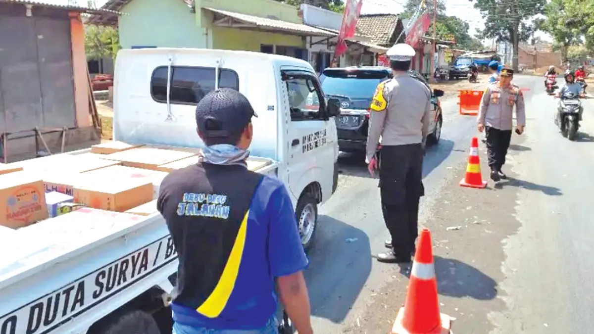 PEMBATASAN: Kapolsek Wongsorejo AKP Eko Darmawan (tengah) membatasi sejumlah kendaraan yang hendak ke Banyuwangi, Selasa (8/9). (EKO for Radar Banyuwangi)