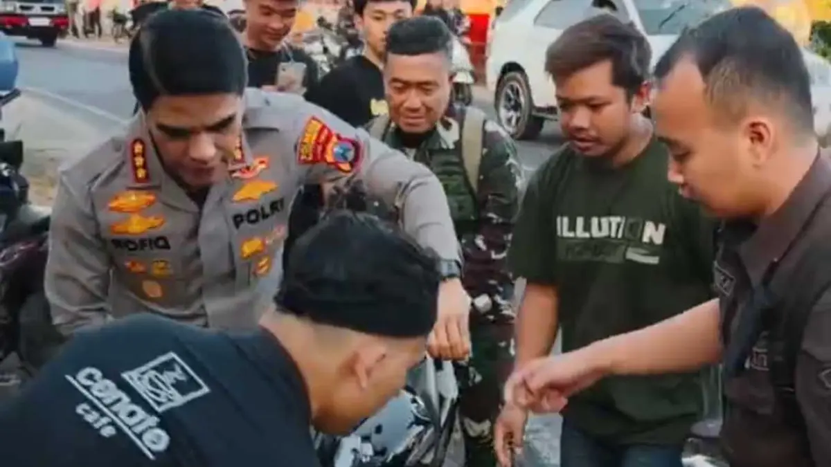 BANTU EVAKUASI: Kapolresta Banyuwangi Kombespol Rofiq Ripto Himawan membantu warga mengevakuasi motor korban kecelakaan di Jalan Raya Winduri, Desa Banjarsari, Kecamatan Glagah, Selasa (8/9). (Humas Polresta Banyuwangi)