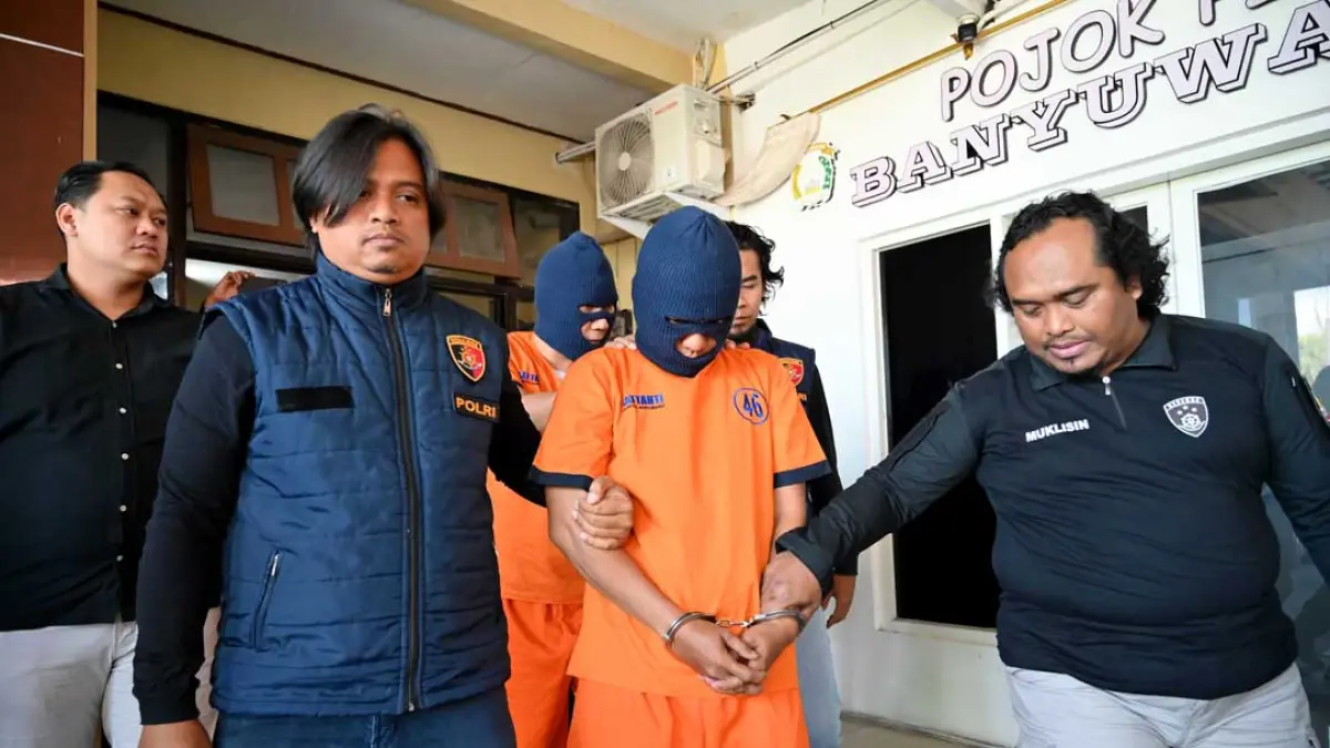 JARINGAN INTERNASIONAL: Tersangka curat dengan modus pecah kaca mobil, Ari Said alias Ari Sanjaya, 37, dan Alex Candra, digiring tim URC Polresta Banyuwangi. (Ramada Kusuma/Radar Banyuwangi)