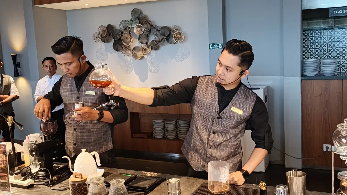 Barista sedang merajik sekaligus menjelaskan pembuatan kopi di Ijen Restaurant lantai 3 Kokoon Hotel, Kamis (10/9). (Ksatria Raya/Radar Banyuwangi)