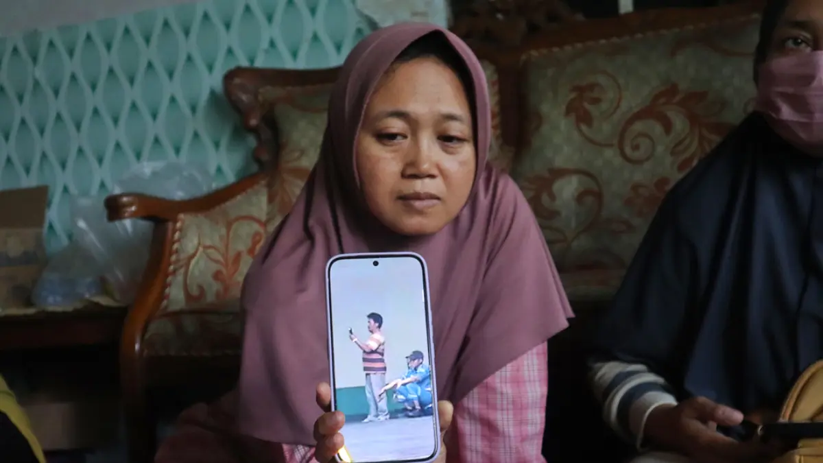 Enik Tri Widayati menunjukkan foto suaminya saat terakhir kali terlihat menaiki kapal, Senin (14/9). (Salis Ali/Radar Banyuwangi)