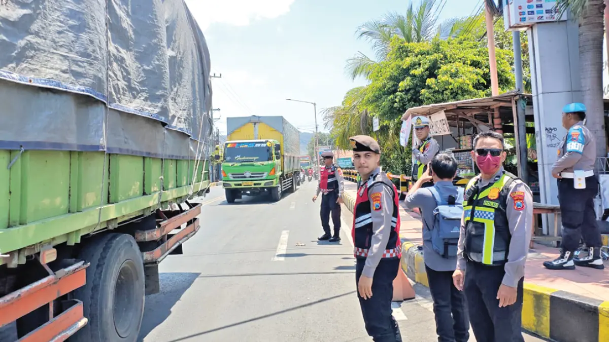 BERI IMBAUAN: Anggota Samapta dan Satlantas Polresta Banyuwangi mengatur arus lalu lintas di dekat Pelabuhan ASDP Ketapang, Kamis (17/9). (KUSMIN for Radar Banyuwangi)