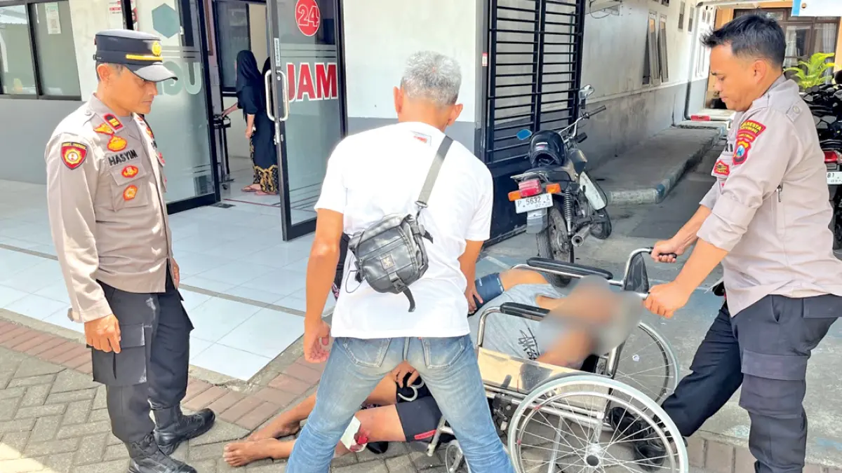 PAKAI KURSI RODA: Petugas kepolisian mengevakuasi salah satu pelaku pencurian jeruk ke rumah sakit. (ISTIMEWA)