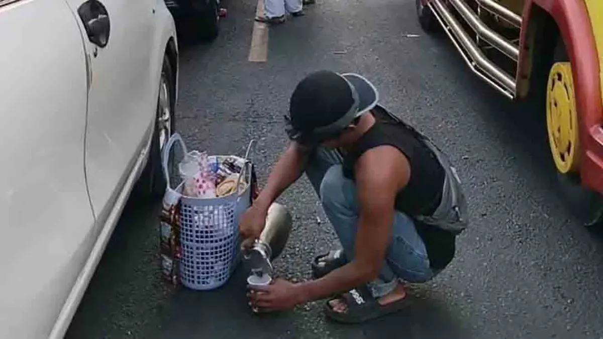 DITINGGAL NGOPI:  Kendaraan yang ditumpangi rombongan keluarga tak bisa bergerak saat melintas di sebelah utara Depo Pertamina Ketapang. Sembari menunggu kepadatan terurai, pengendara menyempatkan bikin kopi di tengah jalan. (Agus Dani for Radar Banyuwangi)