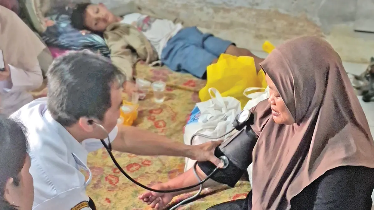 BANTUAN: Tenaga Kesehatan dari Puskesmas Gentengkulon memeriksa tekanan darah Rini Handayani, Jumat (18/9). (Salis Ali/Radar Banyuwangi)