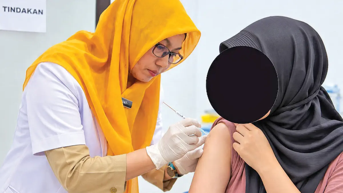 PERLINDUNGAN DIRI: Tenaga medis RSUD Genteng menyuntikkan vaksin pada pasien untuk mencegah influenza. (RSUD Genteng for Radar Banyuwangi)
