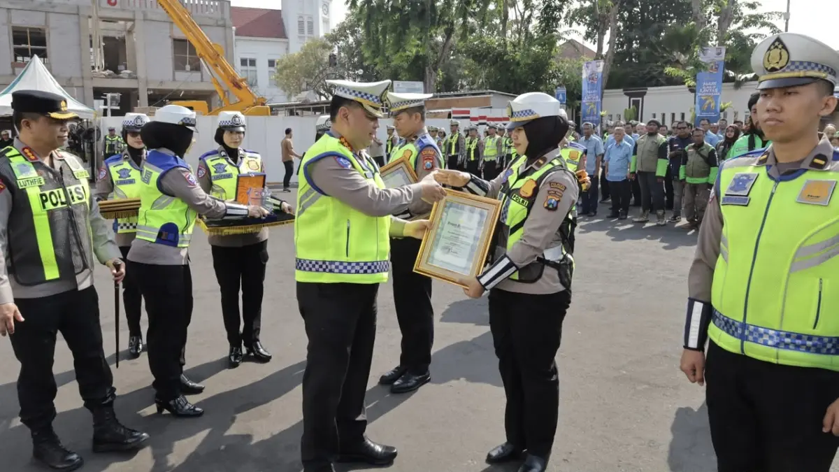 Dirlantas Polda Jawa Timur Kombespol Rahmat Hakim (kiri) menyerahkan penghargaan kepada Kanit Kamsel Satlantas Polresta Banyuwangi Ipda Irvin Venda Rosida di Mapolrestabes Surabaya, Selasa (22/9). Penghargaan diberikan atas dedikasi Satlantas dalam membangun citra positif Polantas melalui media sosial. (Satlantas untuk Radar Banyuwangi)