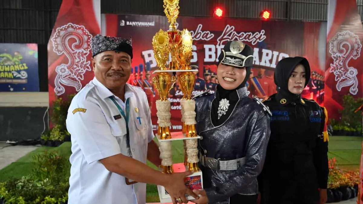 PLT Kadispendik Alfian memberikan piala kepada juara LKBB Banyuwangi 2026. (Ramada Kusuma/Radar Banyuwangi)