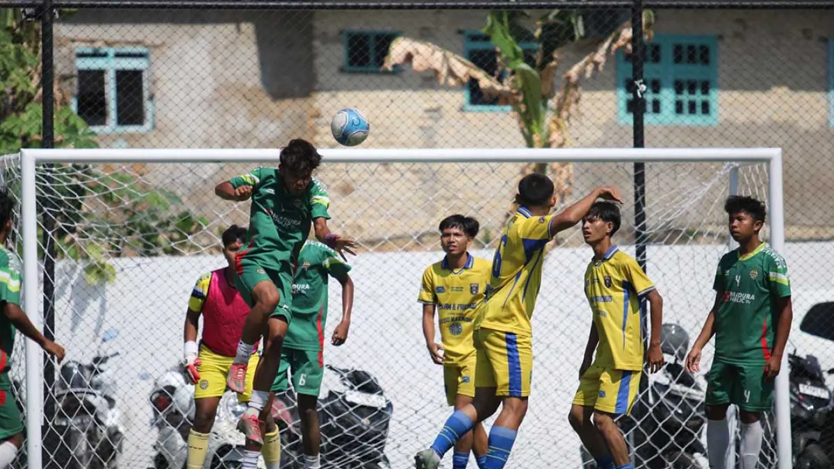 KETAT: Pemain MAN 2 Pamekasan (jersey hijau) menghalau bola atas saat mendapat serangan dari pemain-pemain SMAN 4 Pamekasan di Turnamen Bahlil Mini Soccer Asyik Menuju Puncak Zona 8 Madura di Puri Dewata Mini Soccer Pamekasan, Jumat (25/9).(FAHMI JALIL/RADAR MADURA)