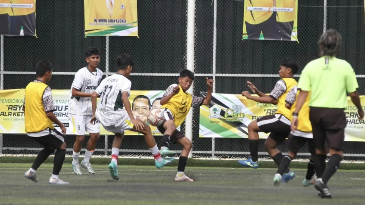 Penggawa SMAN 4 Pasuruan (kostum putih) berebut bola dengan pemain SMKS Untung Suropati Pasuruan di babak 16 besar. (MUKHAMAD ZUBAIDILAH/RADAR BROMO)