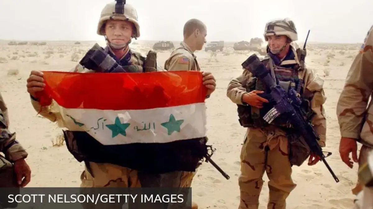 Tentara AS memamerkan bendera Irak saat invasi militer 2003 silam.