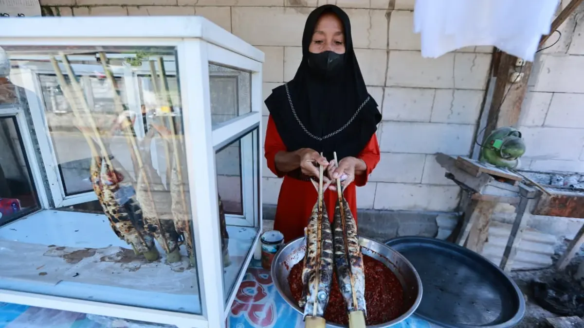 Pedagang memperlihatkan ikan asap dan bumbu tradisional di kawasan Blimbingsari, Banyuwangi. (Pemkab Banyuwangi)