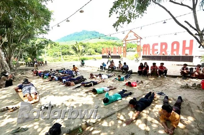 PADLING: Seluruh peserta berlatih mendayung dengan kedua tangan di atas papan selancar sebelum terjun ke laut pada Sabtu (21/5). (Irham Muzaki/Radar Genteng)