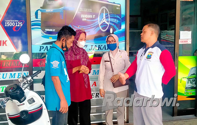 PULKAM: Anggota tim TRC dan perwakilan dari Polsek Genteng mengantar Dwi Susanti (dua dari kiri) asal Ngawi yang terlantar di Banyuwangi mencari tiket bus, Kamis (26/5). (Nur Kholis for Radar Genteng)