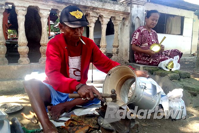PEKERJA KERAS: Sahmo, warga Desa Juglangan, Kecamatan Kapongan, memperbaiki dandang nasi di pinggir jalan Desa Juglangan, Kecamatan Panji, Selasa (7/6). (Humaidi/Radar Situbondo)